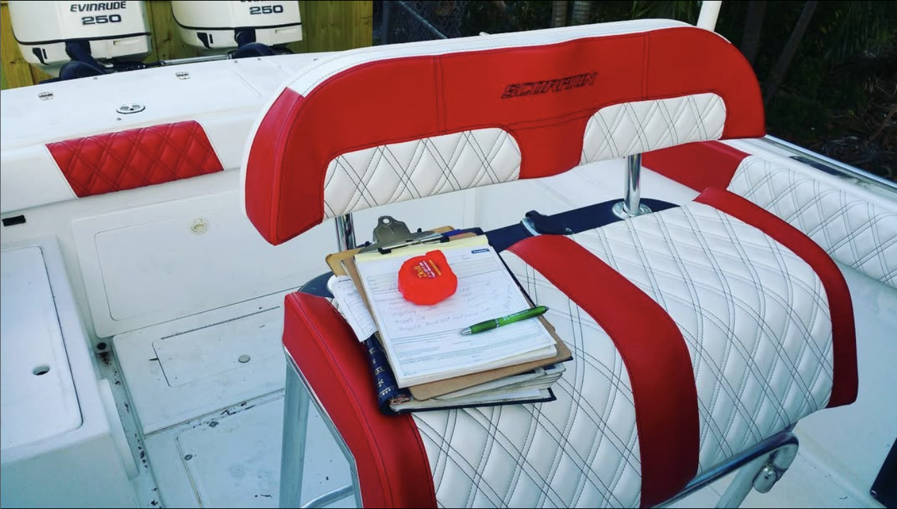 Red and white speedboat interior with quilted seats and clipboard with documents