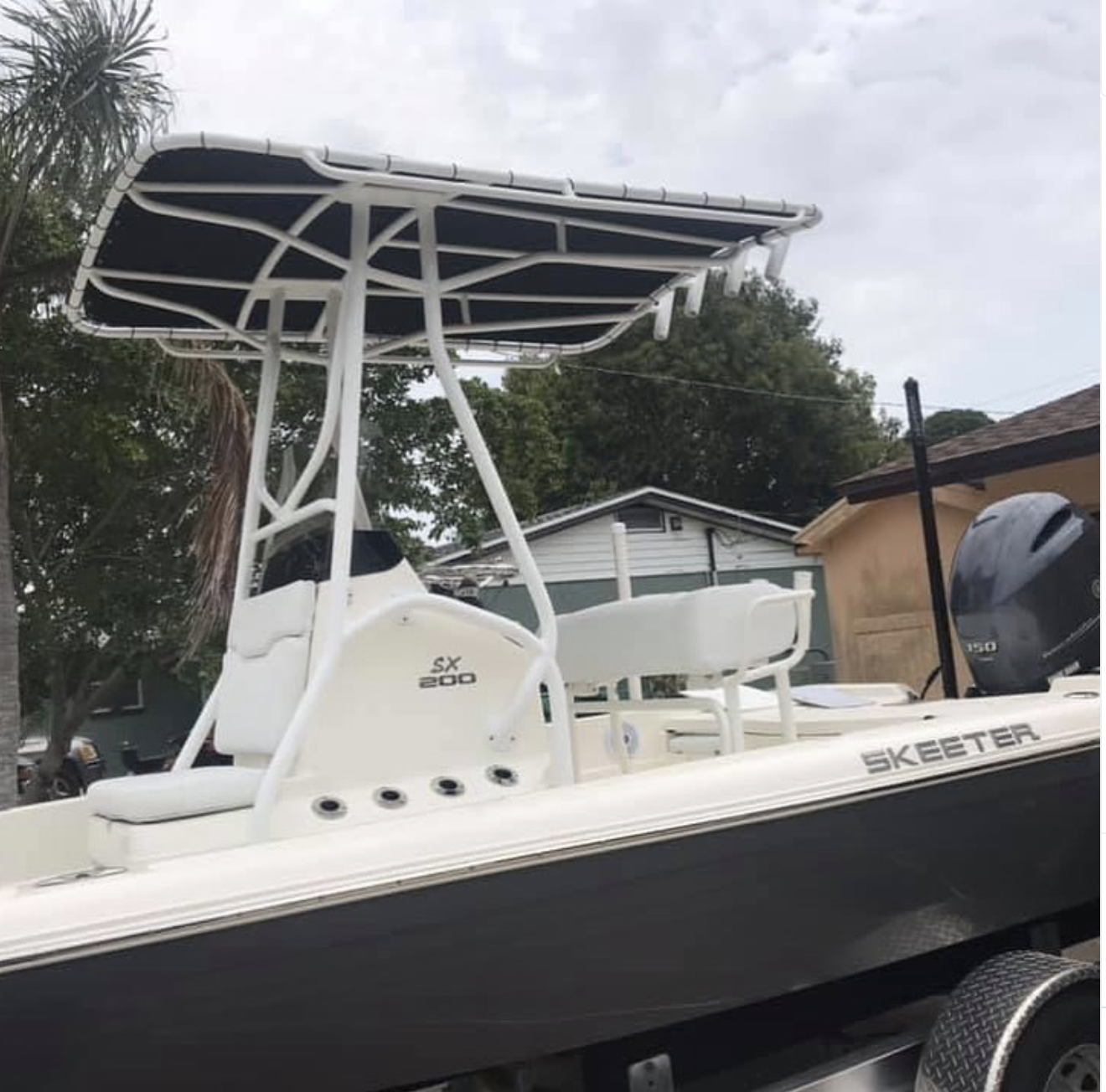 White Skeeter SX 200 fishing boat with T-top canopy and black hull on trailer