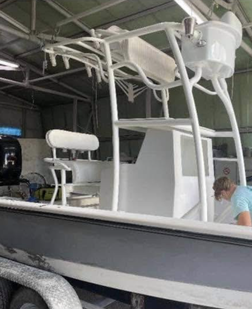 Custom boat hardtop canopy with white frame and railings under construction in industrial facility